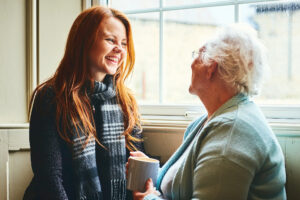Young caregiver woman home care. talks with senior woman about