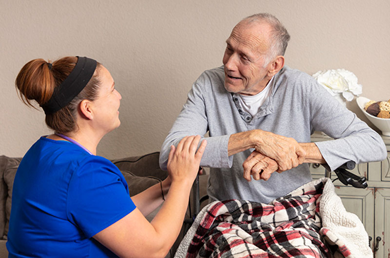 home caregiver comforting senior man on Hospice