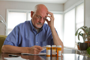 An older man goes over his medications to see if he is taking any medications linked to falls.