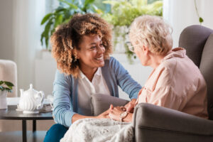Nevada home care provider holding hands with and smiling at elderly woman